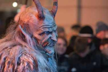 Gece festivalinde boynuzlu ve kürklü Krampus profili