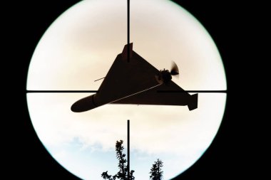 Optik görüşe sabitlenmiş askeri bir dronun silueti.