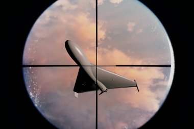 Gün batımının arka planında, bulutların ve gökyüzünün ardında askeri bir dron görünüyor.