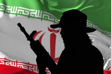 Tüfekli silahlı bir adamın silueti İran bayrağının arka planında sallanıyor.