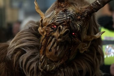 Krampus, boynuz şeklini ve kürk dokusunu vurgulayarak, yakın görüntüde eğik başlı olarak gösterilir.