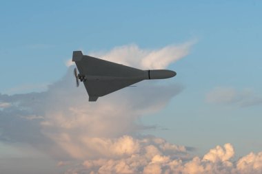 Yumuşak bulutlara karşı gökyüzünde uçan askeri hava aracı..