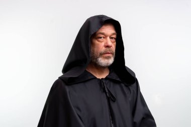 Siyah manastır elbiseli yaşlı erkek keşiş beyaz arka planda, stüdyoda izole edilmiş.