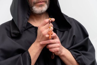 Keşiş ellerinin elinde tespih ve beyaz arka planda çaprazlama.