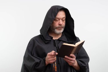 Kapüşon takan sakallı keşiş elinde kitap ve beyaz arka planda tespih.