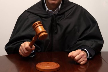 Cüppeli yargıç tokmağını tuttu ve mahkeme kararını vermeye hazırlanıyor.