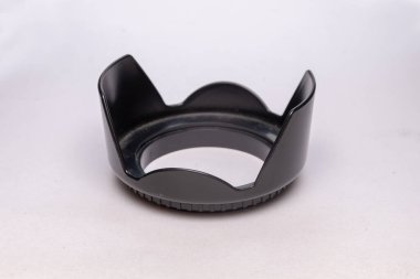 Siyah kamera merceği kaputu, ışık izole edilmiş bir arkaplanda duruyor