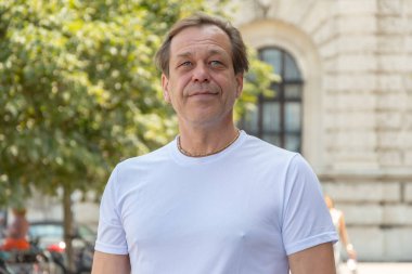 Şehir merkezinde güneşli bir yaz gününde yetişkin Avrupalı bir adamın sokak portresi