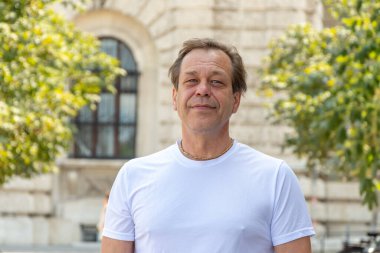 Güneşli yaz havasında beyaz tişörtlü bir adamın Avrupa kentsel portresi