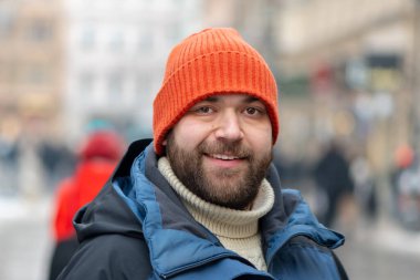 35 year old man on a city street among pedestrians in winter day