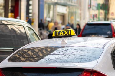 Avusturya şehir caddesinde yayalar arasında sarı işaretli taksi..