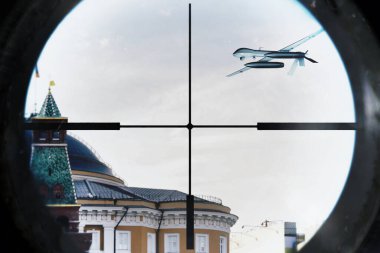 İnsansız hava aracı şehrin üzerinde uçuyor. Optik dürbünden görülüyor.