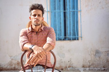 çekici bir adam sandalyede oturuyor