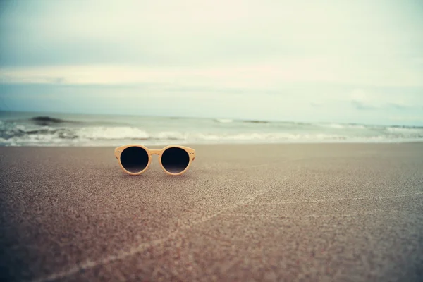 Óculos de sol na praia de areia — Fotografia de Stock