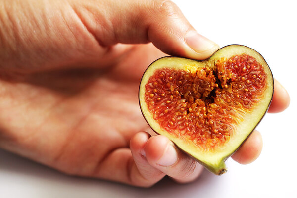 Hands holding figs in heart shape