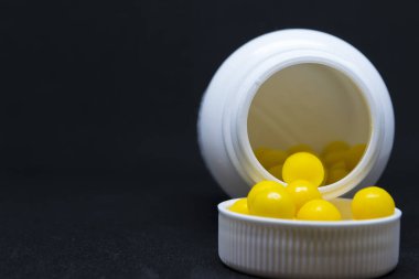 Vitaminler ve arka planda beyaz bir kavanoz..