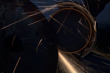 Elektrikli testereyle metal bir boru kesmek. Kıvılcımlar