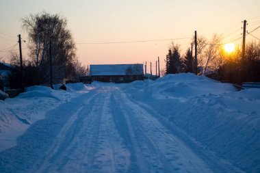 Yol tamamen karla kaplı, sabah güneşi, kar temizleme..
