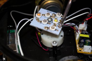 Tahtadaki kabloları lehim demiriyle sabitle. Makineler tamir ediliyor.