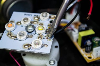 Tahtadaki kabloları lehim demiriyle sabitle. Makineler tamir ediliyor.