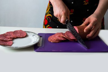 Siyah bıçakla sosis dilimlemek..