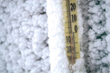 The thermometer is covered in snow after the storm. clipart
