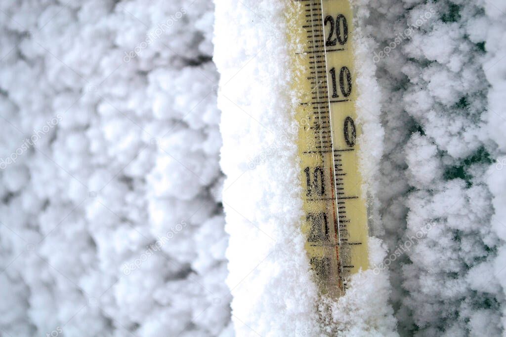 The thermometer is covered in snow after the storm.