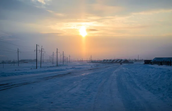 Winter morning, snowy road, morning sun.