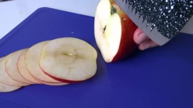 Kırmızı bir elmayı mavi bir kalasta dilimliyorum..