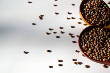 Organik çiğ mercimek, ahşap tepsi, çuval bez, stüdyo görüntüsü.