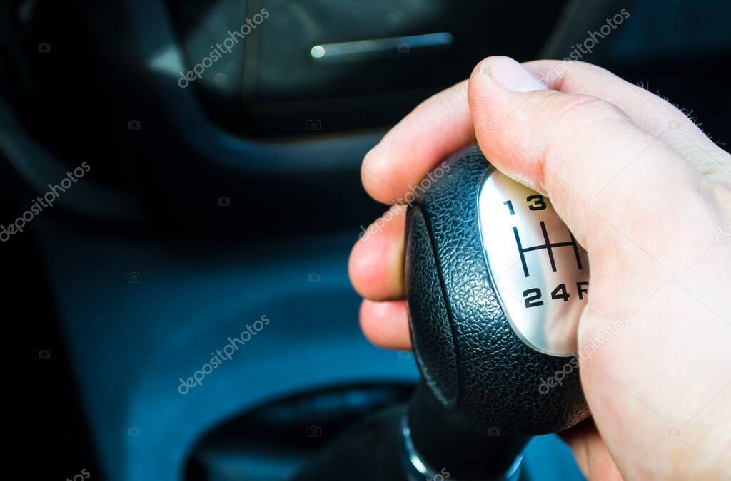 Male driver hand shifting gears by hand. A man driving a car