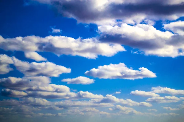 Nuvens brancas fofas bonitas em um céu azul profundo — Fotografia de Stock