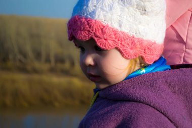 Küçük bir kız annesiyle el ele tutuşuyor..