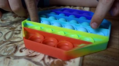 Çocuk POP IT 'u elinde tutuyor, modern aletlere ara veriyor..