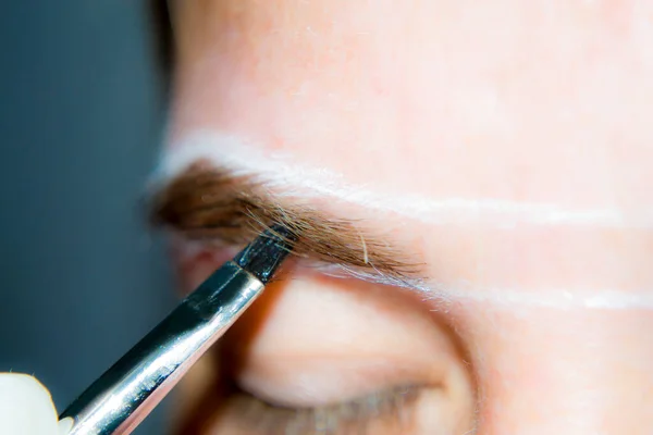 Una chica se somete a corrección de cejas en el hogar de comunicaciones pandémicas. Negocio doméstico. — Foto de Stock