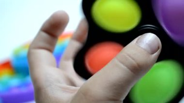 Çocuk POP IT 'u elinde tutuyor, modern aletlere ara veriyor..