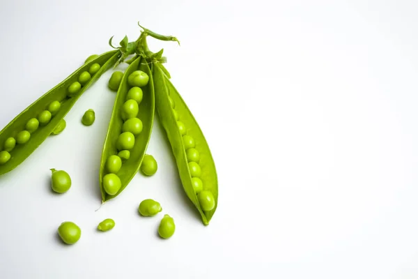 Schoten grüner Erbsen auf weißem Hintergrund — Stockfoto