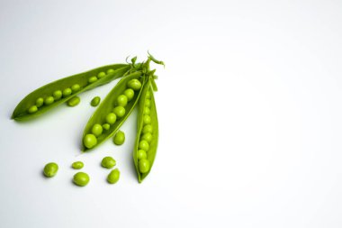 Beyaz arkaplanda yeşil bezelye kabukları