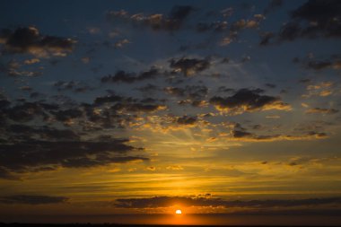 Akşam batımı mavi gökyüzüne doğru ilerlerken tüylü bulutlar, doğanın romantik ortamı....