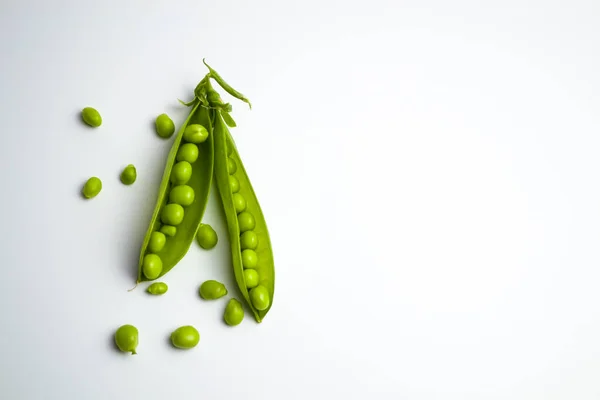 Schoten grüner Erbsen auf weißem Hintergrund — Stockfoto