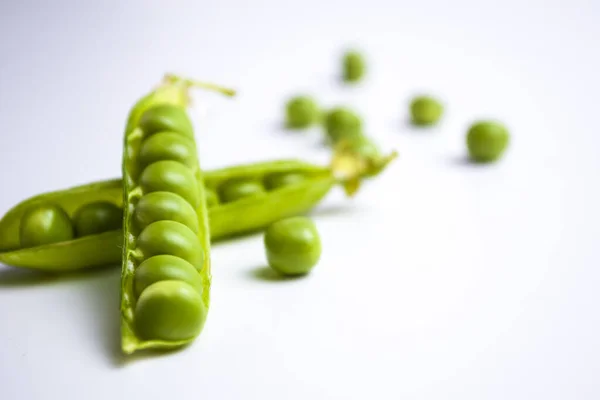 Grüne reife Erbsen, grüne Bohnen auf weißem Hintergrund, vegetarisches Essen aus nächster Nähe — Stockfoto