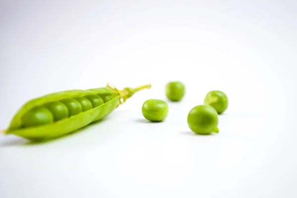 Fallende grüne Erbsen isoliert auf weißem Hintergrund mit Schnittpfad — Stockfoto
