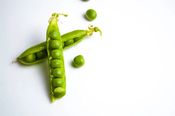 Erbsen vor weißem Hintergrund. Vertikales Foto von Tupfen. — Stockfoto