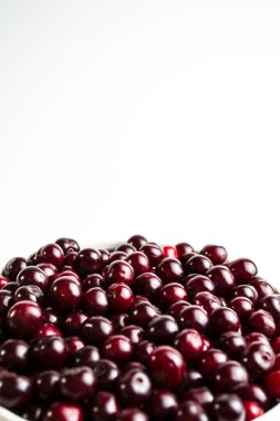 Beyaz arka planda kiraz, telefonunda güzel bir ekran koruyucu, yemek pişirme ve kiraz çileklerinin faydaları hakkında bir web makalesi. Kiraz çileğindeki tüm makro elementlerin içeriği.