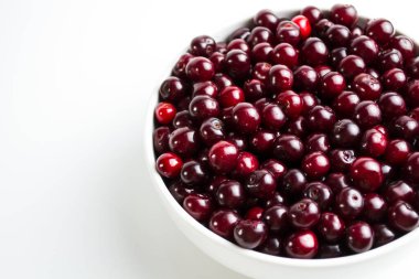 Beyaz arka planda kiraz, telefonunda güzel bir ekran koruyucu, yemek pişirme ve kiraz çileklerinin faydaları hakkında bir web makalesi. Kiraz çileğindeki tüm makro elementlerin içeriği.