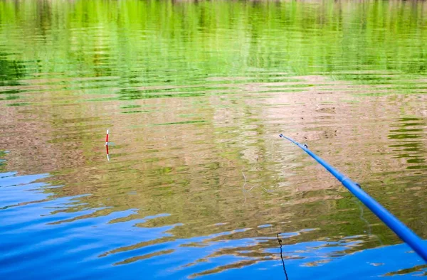 Caña de pescar y flotar, pescar en el río. Pesca o recreación al aire libre. — Foto de Stock