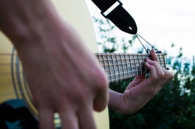 Mutlu genç adam evin dışında gitar çalıyor.