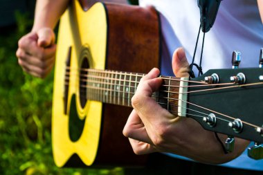 Mutlu genç adam evin dışında gitar çalıyor.