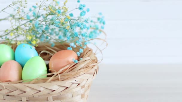 Egy férfi keze húsvéti tojást tesz a kosárba.. — Stock videók