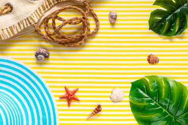 Yaz kompozisyonu. Tropik palmiye yaprakları, çanta, deniz kabuğu, sarı arka planda şapka. Sarı arka planda yaratıcı bir yaz kompozisyonu. Üst görünüm.